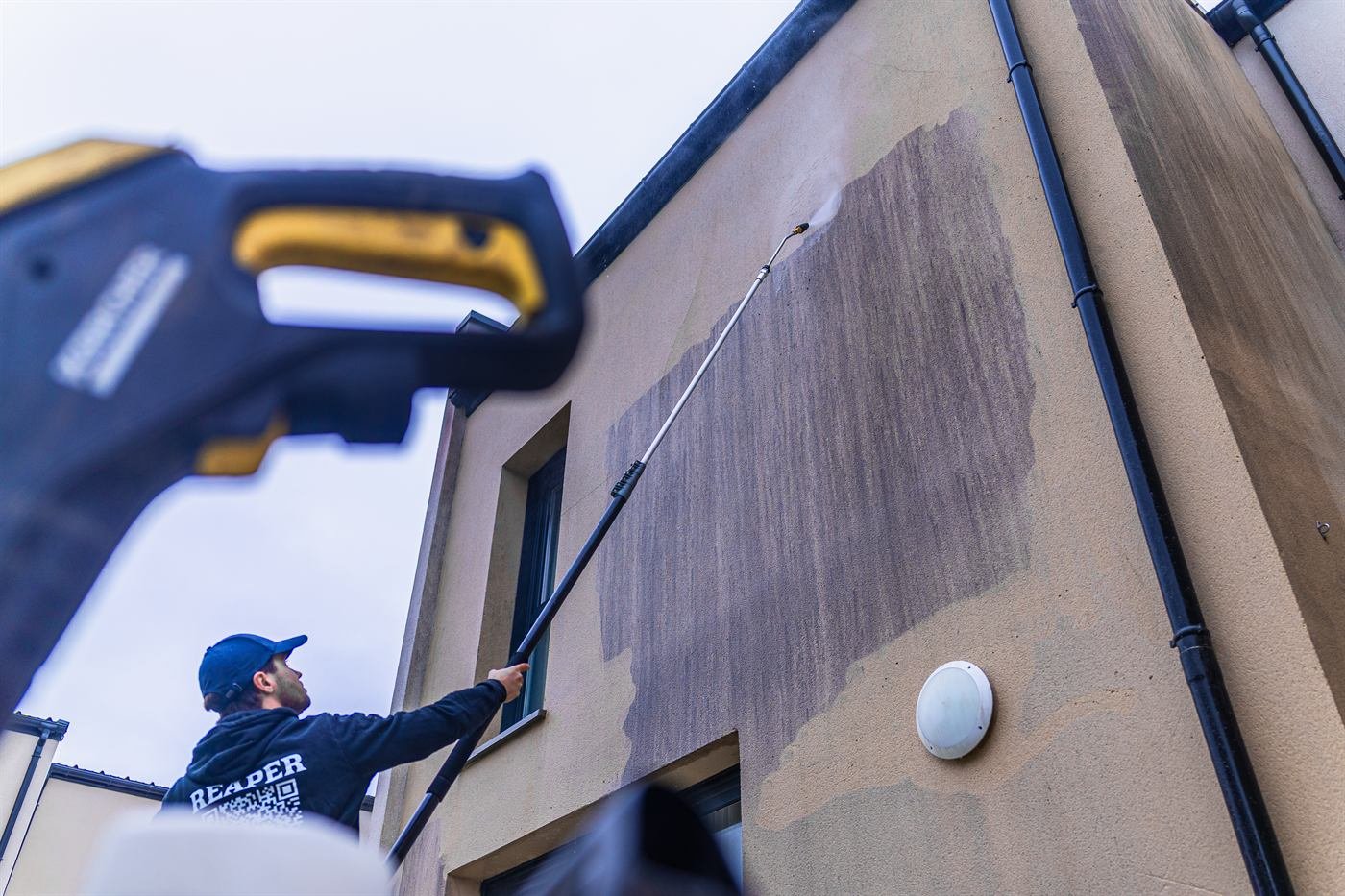 Nettoyage d’une façade enduite depuis le sol, à la lance sur perche